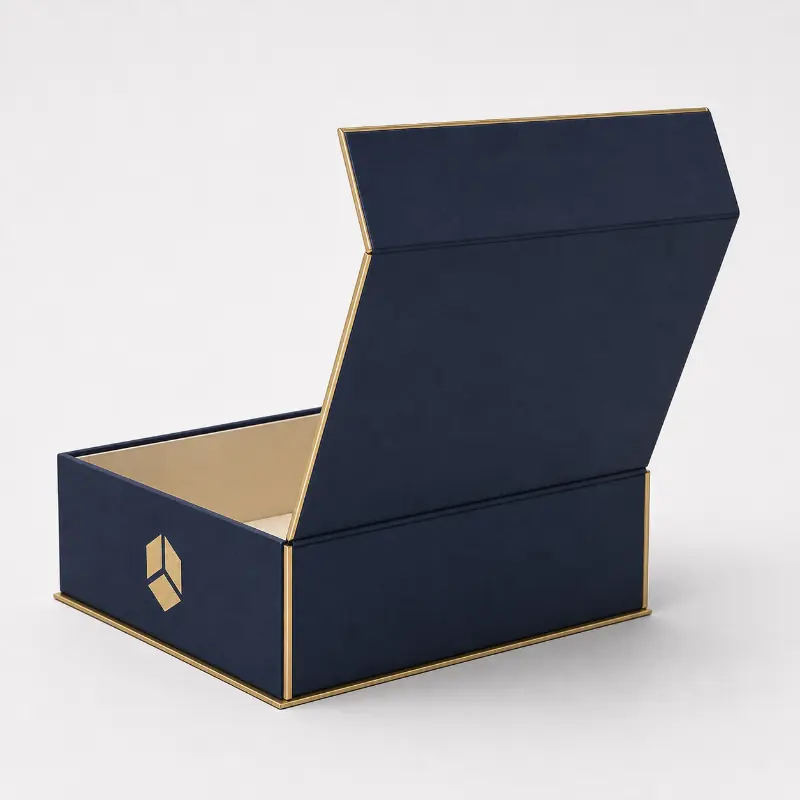 Open collapsible magnetic lid rigid box in navy with gold trim and cream interior.