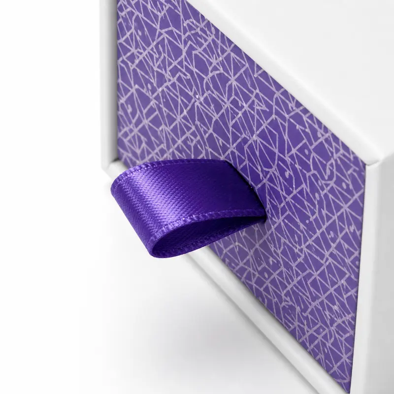 Close-up of the purple ribbon pull loop on a custom rigid drawer box.